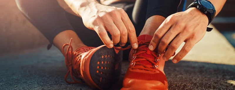 Runner tying running shoes